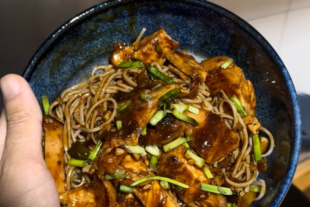 Chili chicken soba — chicken and soba noodles in a glossy dark-red chili sauce topped with spring onions