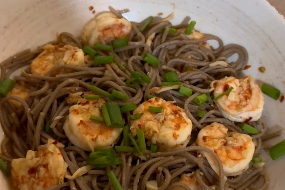 Chili garlic shrimp soba — prawns and buckwheat noodles in a glossy sauce with scallions, in a bowl