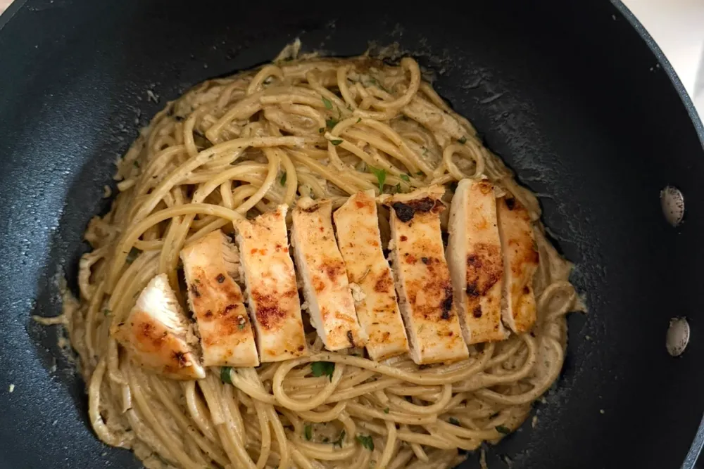 Tabasco chicken Alfredo — sliced golden chicken over creamy pasta with parsley, in a pan